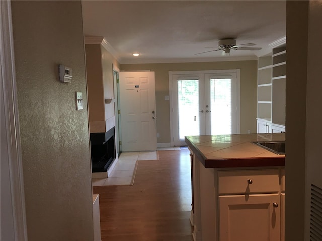 18617 Egret Bay Blvd Unit 303, Webster, TX 77058 - kitchen featuring tile counters, ceiling fan, ornamental molding, light wood finished floors, and french doors