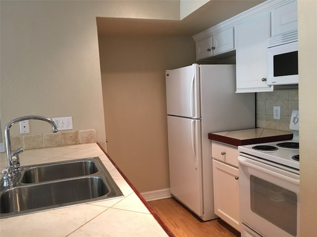 18617 Egret Bay Blvd Unit 303, Webster, TX 77058 - kitchen featuring white appliances, a sink, tile counters, backsplash, and white cabinetry