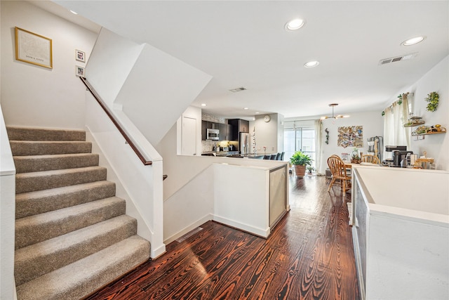 429 Meadow St, Houston, TX 77020 - kitchen with dark wood finished floors, a peninsula, recessed lighting, decorative light fixtures, and a chandelier