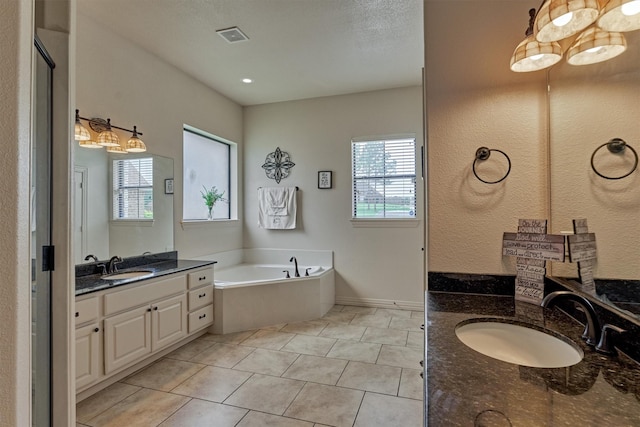 11848 Seashell Cir, Montgomery, TX 77356 - bathroom featuring healthy amount of natural light, a bath, two vanities, and tile patterned flooring