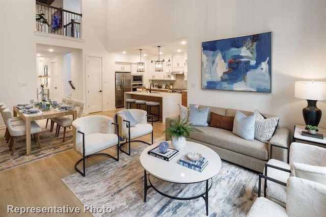 2296 Vargas St, Magnolia, TX 77316 - living area with light wood-style floors, a towering ceiling, and baseboards