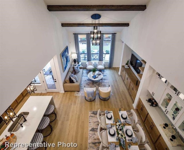 2296 Vargas St, Magnolia, TX 77316 - living area with a chandelier, light wood-type flooring, beamed ceiling, and baseboards