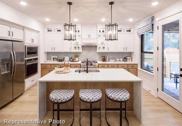 2296 Vargas St, Magnolia, TX 77316 - kitchen with appliances with stainless steel finishes, a sink, a breakfast bar area, a chandelier, and recessed lighting