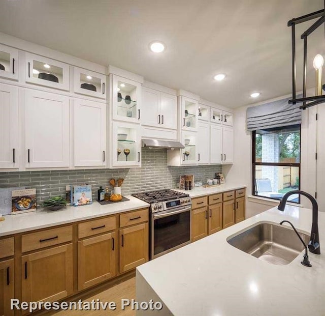2296 Vargas St, Magnolia, TX 77316 - kitchen featuring stainless steel range with gas cooktop, a sink, light countertops, tasteful backsplash, and white cabinetry