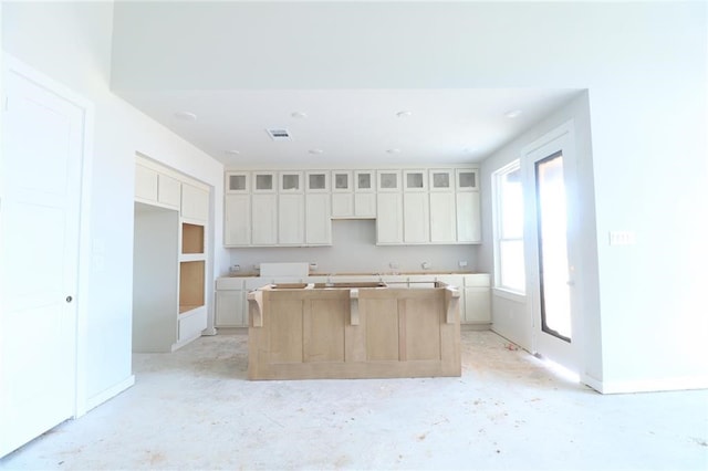2296 Vargas St, Magnolia, TX 77316 - kitchen with a center island, baseboards, glass insert cabinets, and white cabinets