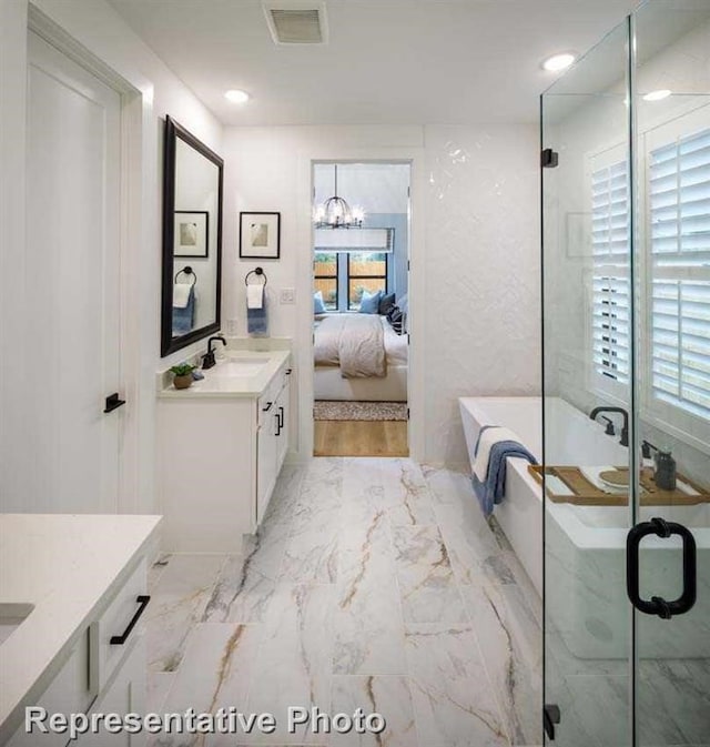 2296 Vargas St, Magnolia, TX 77316 - ensuite bathroom featuring vanity, a soaking tub, marble look tiles, a stall shower, and a chandelier