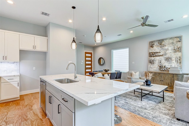 1830 W Tidwell Rd, Houston, TX 77091 - kitchen featuring open floor plan, light wood-type flooring, dishwasher, light stone counters, and a center island with sink