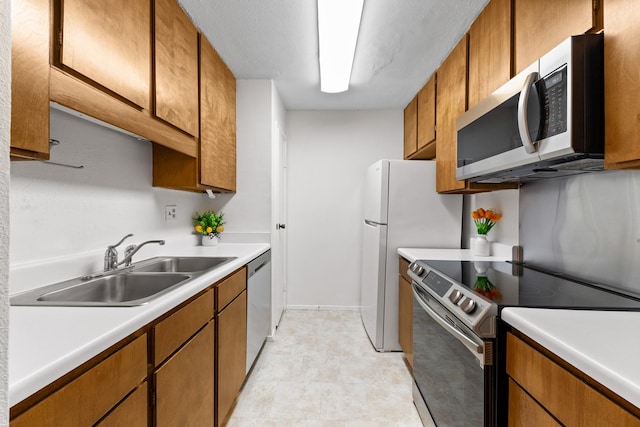 10053 Westpark Dr Unit 332, Houston, TX 77042 - kitchen with appliances with stainless steel finishes, a sink, and brown cabinets