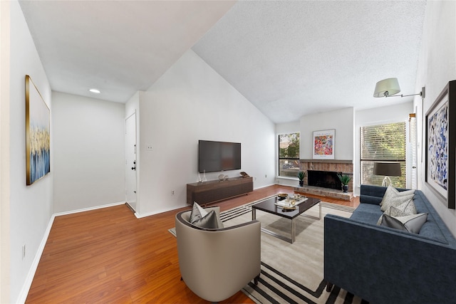 10053 Westpark Dr Unit 332, Houston, TX 77042 - living room with wood finished floors, a fireplace, baseboards, and a textured ceiling
