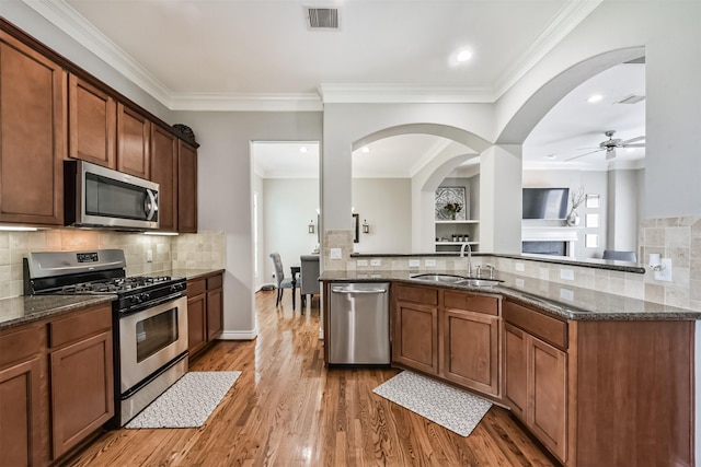 8806 Lakeshore Bend Dr, Houston, TX 77080 - kitchen featuring appliances with stainless steel finishes, decorative backsplash, a ceiling fan, dark stone counters, and recessed lighting
