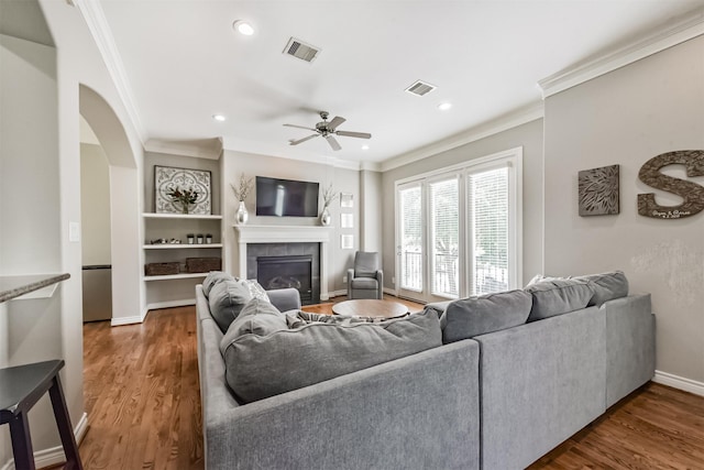8806 Lakeshore Bend Dr, Houston, TX 77080 - living area with crown molding, a fireplace, ceiling fan, wood finished floors, and recessed lighting