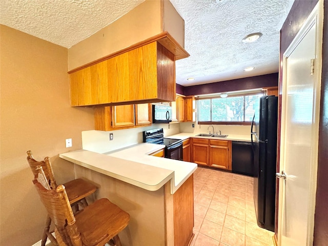 3823 Knollcrest Dr, Montgomery, TX 77356 - kitchen with black appliances, a sink, a peninsula, a textured ceiling, and brown cabinets