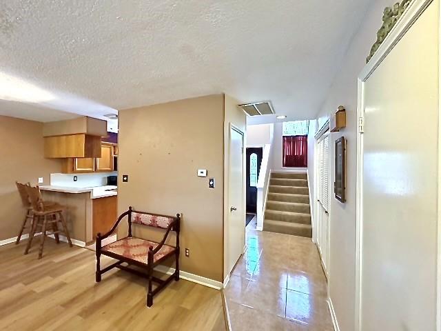 3823 Knollcrest Dr, Montgomery, TX 77356 - hall featuring a textured ceiling, baseboards, light wood-style floors, and stairway