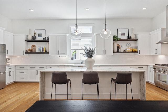 1402 Missouri Unit B, Houston, TX 77006 - kitchen featuring open shelves, appliances with stainless steel finishes, white cabinetry, a breakfast bar, and recessed lighting