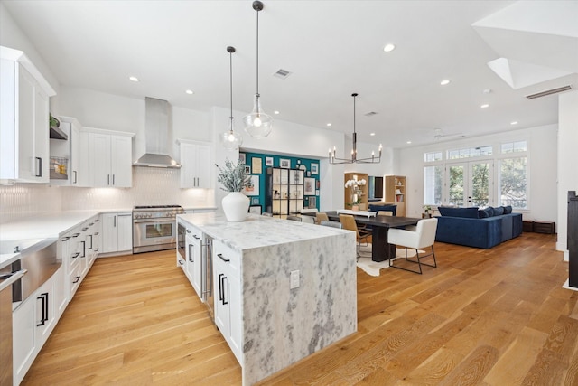 1402 Missouri Unit B, Houston, TX 77006 - kitchen with stainless steel range, wall chimney exhaust hood, a center island, recessed lighting, and open floor plan
