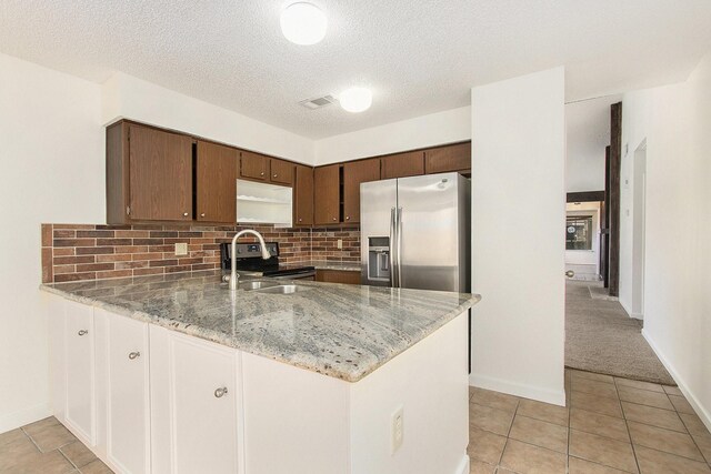 11625 Lakeside Park Dr, Houston, TX 77077 - kitchen featuring stainless steel appliances, a peninsula, tasteful backsplash, light stone counters, and light tile patterned floors