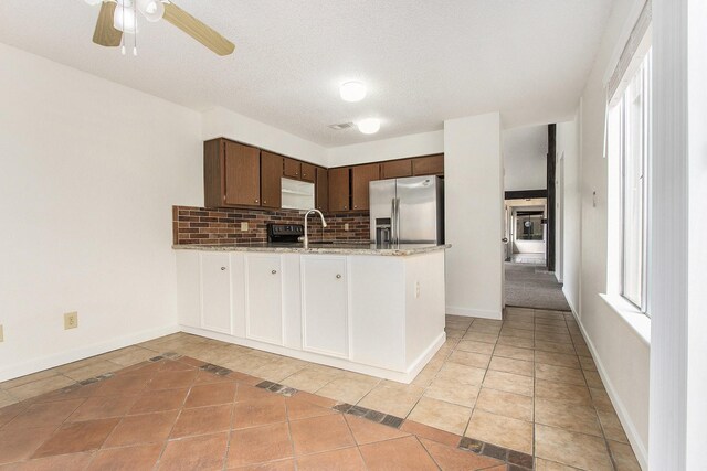 11625 Lakeside Park Dr, Houston, TX 77077 - kitchen with stainless steel fridge with ice dispenser, a peninsula, backsplash, dark brown cabinetry, and a ceiling fan