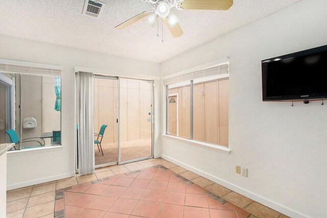 11625 Lakeside Park Dr, Houston, TX 77077 - unfurnished bedroom featuring tile patterned floors, a textured ceiling, and a ceiling fan