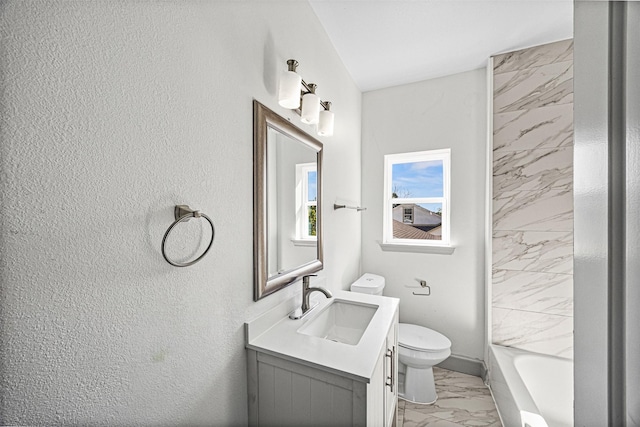 102 Glendale St, Houston, TX 77012 - bathroom with marble look tiles, toilet, vanity, a textured wall, and baseboards