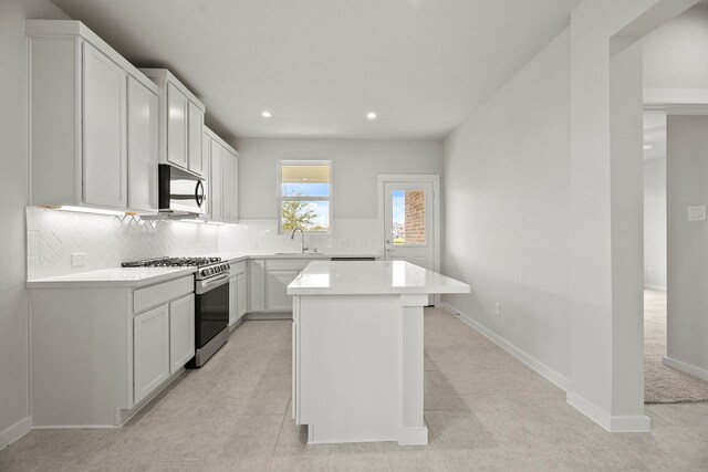 13122 Leisure Cove Dr, Texas City, TX 77568 - kitchen with stainless steel range with gas stovetop, decorative backsplash, light countertops, recessed lighting, and a kitchen island