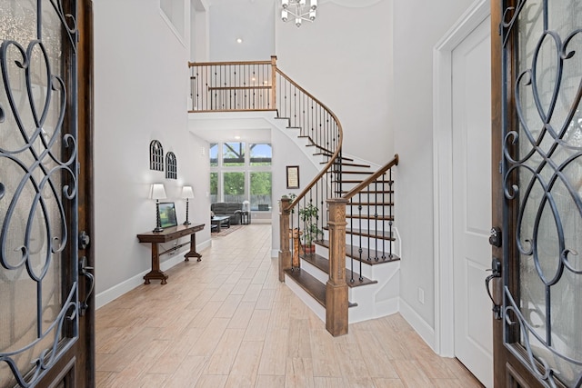 13630 E Palomino Lake Cir, Cypress, TX 77429 - entrance foyer with stairway, baseboards, a towering ceiling, light wood-style flooring, and a chandelier