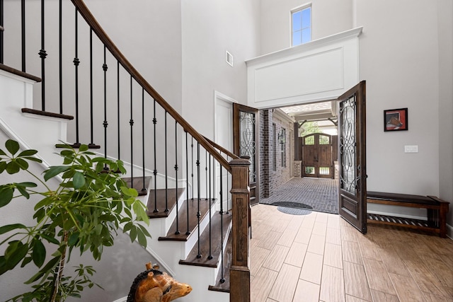 13630 E Palomino Lake Cir, Cypress, TX 77429 - foyer entrance featuring a towering ceiling, stairs, and wood finished floors