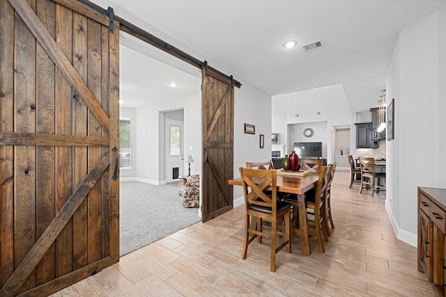 13630 E Palomino Lake Cir, Cypress, TX 77429 - dining space featuring a barn door, light wood finished floors, baseboards, and recessed lighting
