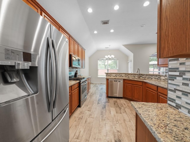 24602 Windemere Park Ct, Katy, TX 77494 - kitchen featuring appliances with stainless steel finishes, a sink, light wood-style floors, brown cabinets, and tasteful backsplash