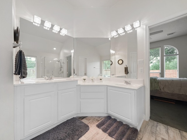 24602 Windemere Park Ct, Katy, TX 77494 - ensuite bathroom featuring a shower stall, wood finished floors, double vanity, and vaulted ceiling