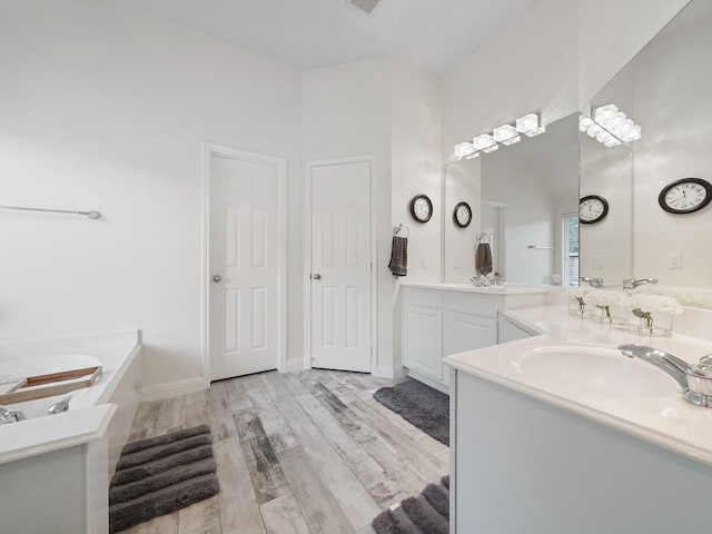 24602 Windemere Park Ct, Katy, TX 77494 - bathroom featuring vanity, wood finished floors, and a garden tub