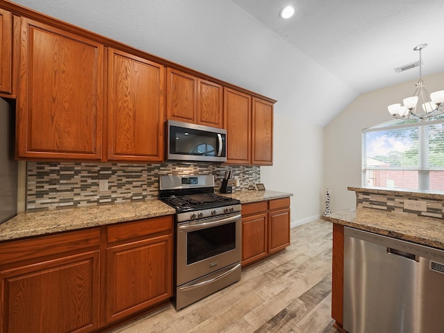 24602 Windemere Park Ct, Katy, TX 77494 - kitchen featuring stainless steel appliances, vaulted ceiling, decorative backsplash, a chandelier, and light wood finished floors