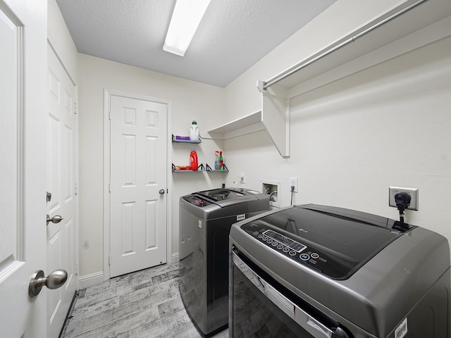 24602 Windemere Park Ct, Katy, TX 77494 - washroom with washer and dryer, light wood finished floors, a textured ceiling, and baseboards