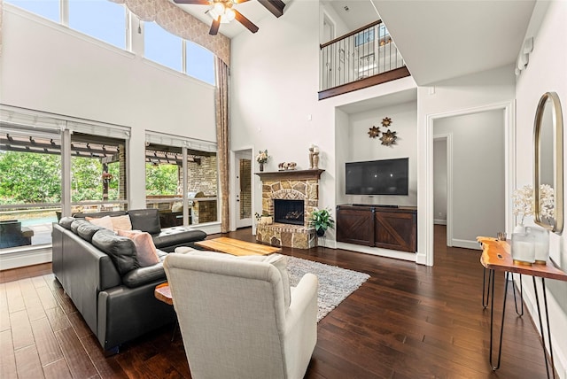 119 W Valera Ridge Pl, Spring, TX 77389 - living room with a towering ceiling, a fireplace, dark wood-type flooring, ceiling fan, and baseboards