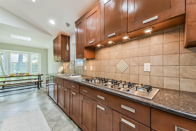 23011 Grand Rapids Ln, Spring, TX 77373 - kitchen featuring a sink, stainless steel gas stovetop, decorative backsplash, lofted ceiling, and dark stone counters