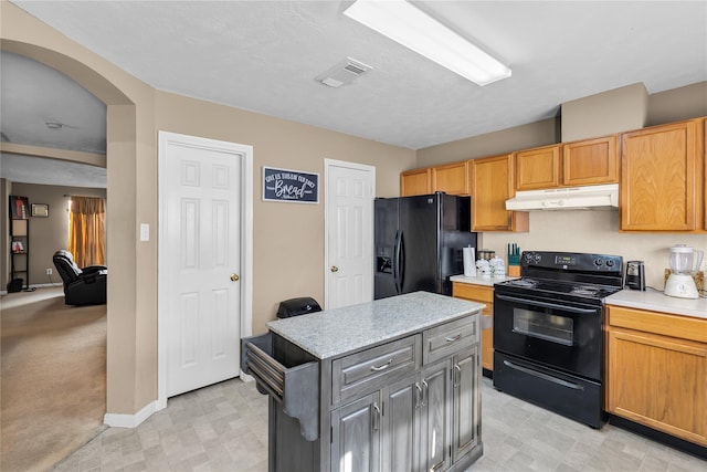 11735 Alief Clodine Rd Unit 34, Houston, TX 77072 - kitchen with black appliances, under cabinet range hood, light countertops, arched walkways, and a kitchen island