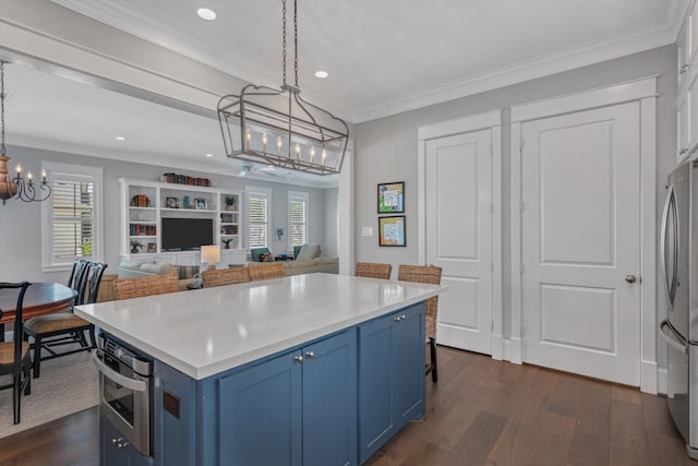 9 Broad St, Galveston, TX 77554 - kitchen with blue cabinets, a chandelier, appliances with stainless steel finishes, dark wood finished floors, and recessed lighting