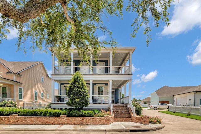 9 Broad St, Galveston, TX 77554 - view of front of house with a balcony, a porch, concrete driveway, and stairs