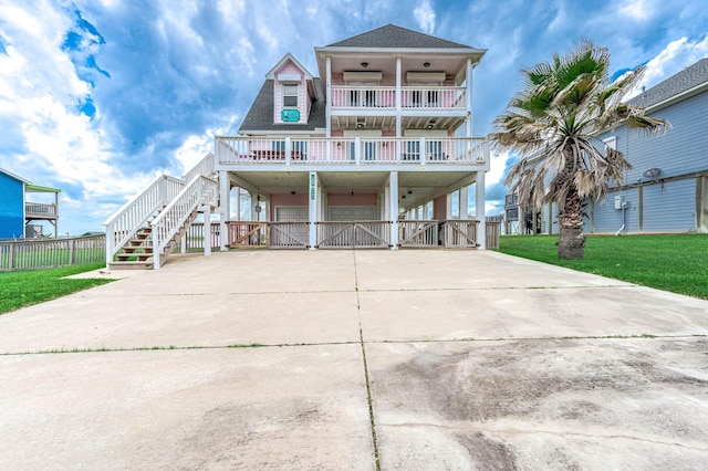 1197 County Road 230, Sargent, TX 77414 - raised beach house featuring a carport, concrete driveway, stairs, roof with shingles, and a balcony