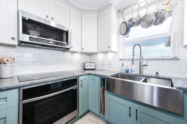 1197 County Road 230, Sargent, TX 77414 - kitchen featuring black appliances, a sink, decorative backsplash, and white cabinetry