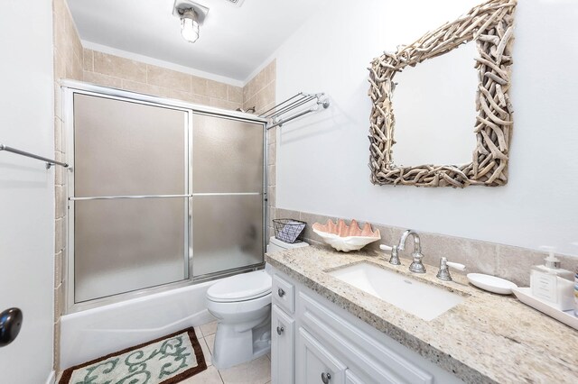 1197 County Road 230, Sargent, TX 77414 - full bathroom featuring toilet, vanity, bath / shower combo with glass door, and tile patterned flooring