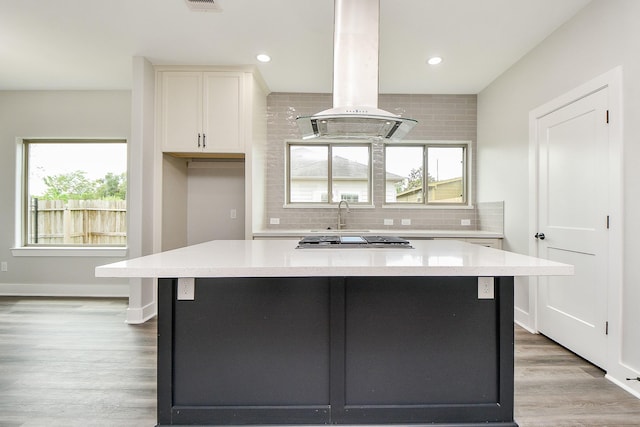 3337 Shelby Cir, Houston, TX 77051 - kitchen featuring island exhaust hood, a center island, decorative backsplash, light countertops, and recessed lighting