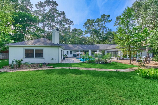 23106 Hampton Forest Ln, Spring, TX 77389 - back of house featuring a yard, a chimney, an outdoor pool, and a patio
