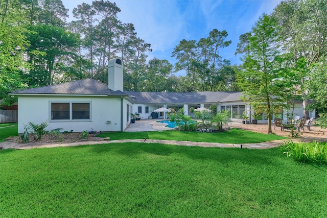 23106 Hampton Forest Ln, Spring, TX 77389 - back of house featuring a yard, a chimney, an outdoor pool, and a patio