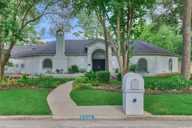 23106 Hampton Forest Ln, Spring, TX 77389 - ranch-style home featuring stucco siding, a shingled roof, a front lawn, and a chimney