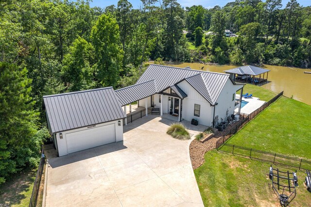 111 Seagull Path, Point Blank, TX 77364 - view of front of home featuring concrete driveway, a metal roof, a standing seam roof, and a boat dock