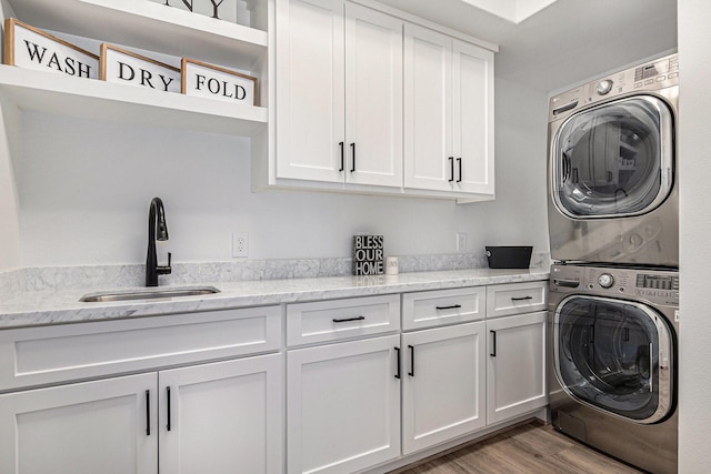 111 Seagull Path, Point Blank, TX 77364 - washroom featuring stacked washing machine and dryer, cabinet space, and wood finished floors