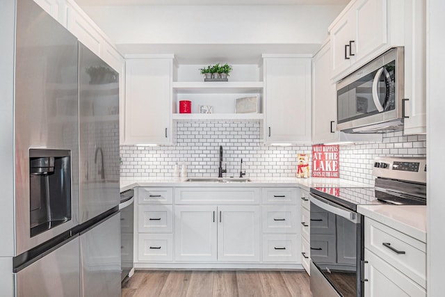 111 Seagull Path, Point Blank, TX 77364 - kitchen with stainless steel appliances, light countertops, white cabinetry, and tasteful backsplash