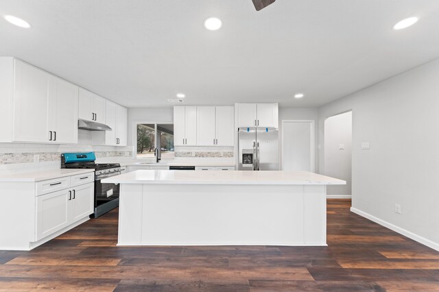 2 Dewthread Ct, The Woodlands, TX 77380 - kitchen with stainless steel appliances, under cabinet range hood, decorative backsplash, a kitchen island, and recessed lighting