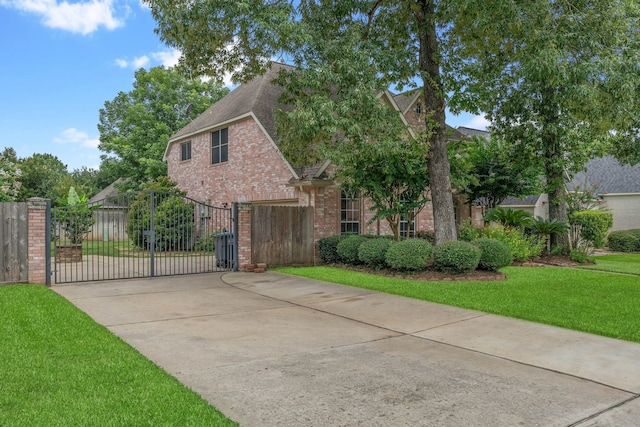 31335 Bearing Star Ln, Tomball, TX 77375 - view of front of house featuring a gate, a shingled roof, brick siding, and concrete driveway