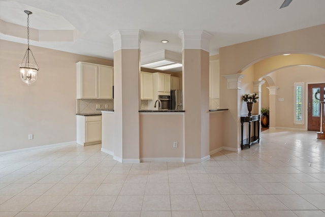 31335 Bearing Star Ln, Tomball, TX 77375 - living room with light tile patterned floors, arched walkways, ceiling fan, and ornate columns